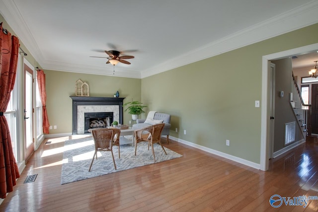 sitting room with a fireplace, visible vents, baseboards, ornamental molding, and wood-type flooring