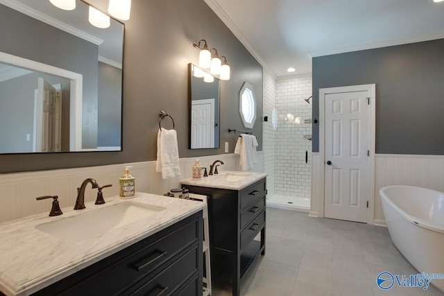 full bath featuring wainscoting, a soaking tub, ornamental molding, a shower stall, and a sink