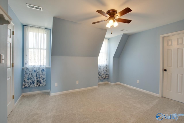 additional living space featuring vaulted ceiling, carpet flooring, visible vents, and baseboards