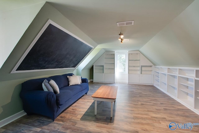 bonus room featuring built in features, baseboards, visible vents, wood finished floors, and vaulted ceiling