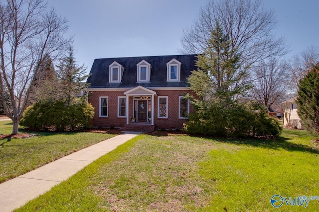 cape cod house with brick siding and a front lawn