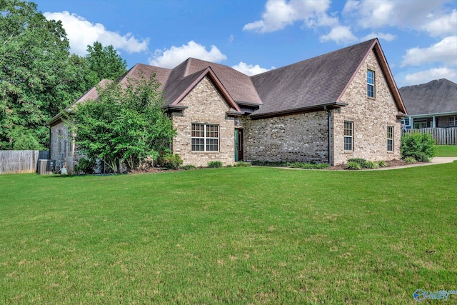 view of front of home featuring fence, a front lawn, and brick siding