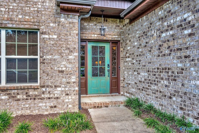 view of exterior entry featuring brick siding