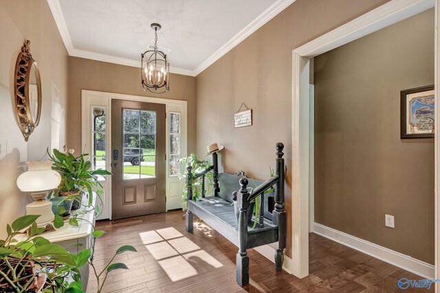 entrance foyer featuring baseboards, a chandelier, crown molding, and wood finished floors