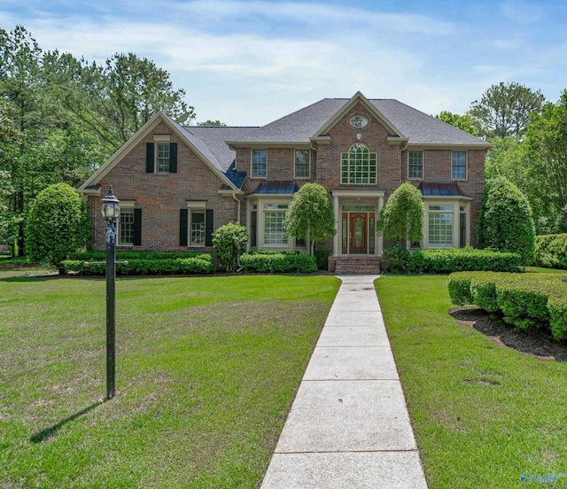 2600 SE Calumet Dr SE, Brownsboro, AL 35741 - georgian-style home with brick siding, a front yard, a shingled roof, and a standing seam roof