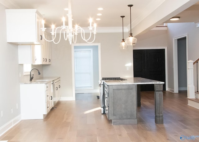 kitchen with pendant lighting, light hardwood / wood-style flooring, a center island, and light stone counters