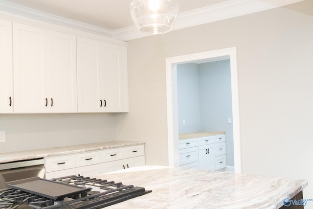 kitchen featuring white cabinets, pendant lighting, crown molding, and light stone counters