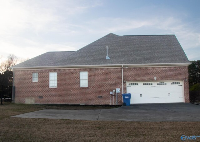 view of side of home featuring a garage and a yard