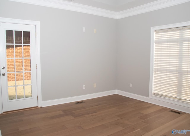 empty room featuring hardwood / wood-style flooring and crown molding