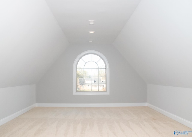 bonus room featuring vaulted ceiling and light colored carpet