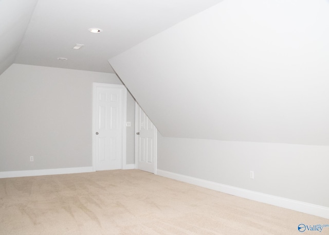 additional living space featuring lofted ceiling and carpet flooring