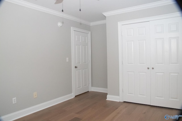 unfurnished bedroom with ceiling fan, crown molding, hardwood / wood-style flooring, and a closet