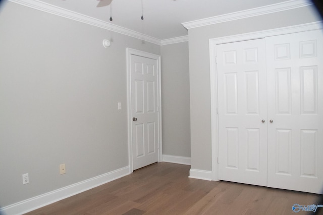 unfurnished bedroom featuring crown molding, ceiling fan, wood-type flooring, and a closet