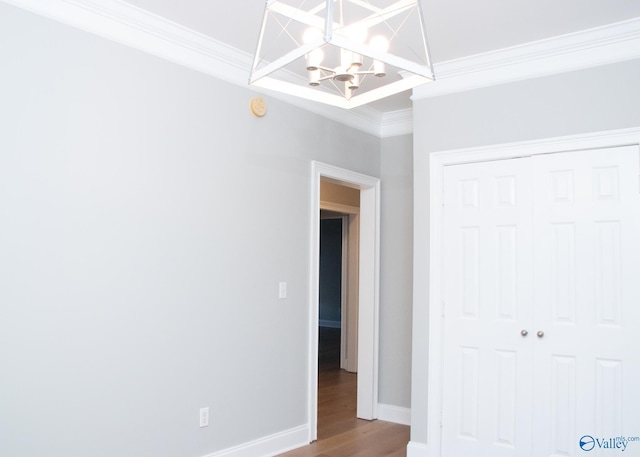 unfurnished bedroom featuring hardwood / wood-style floors, crown molding, and a closet