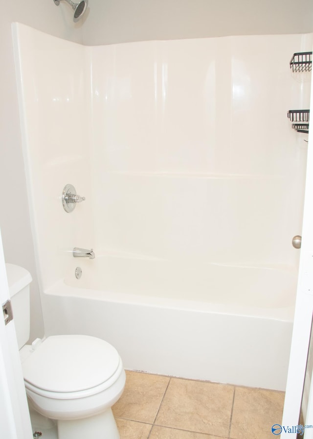 bathroom with toilet, washtub / shower combination, and tile patterned flooring