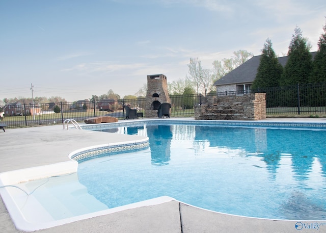 view of swimming pool featuring a fireplace and a patio