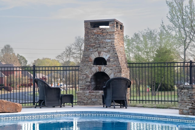 view of swimming pool with an outdoor fireplace