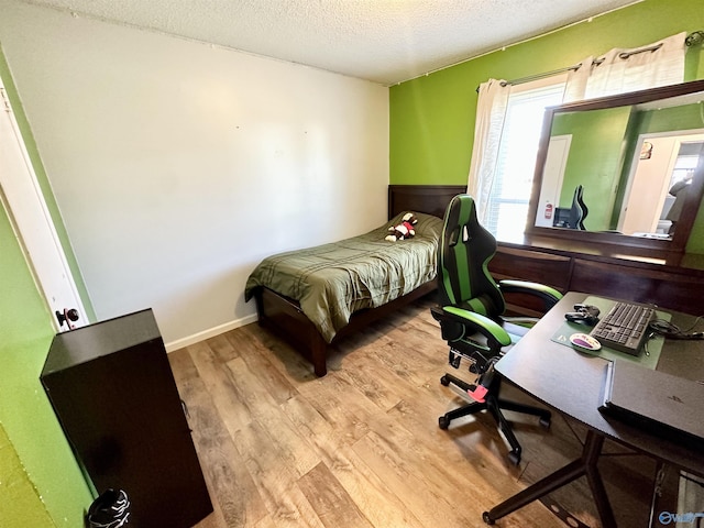 bedroom featuring a textured ceiling and wood finished floors