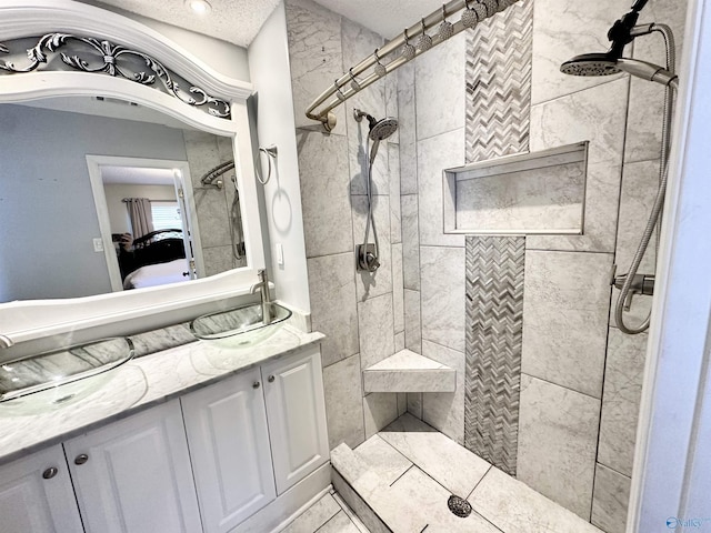 bathroom with vanity, a textured ceiling, ensuite bath, and tiled shower