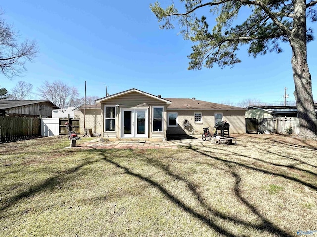 back of house featuring a yard, a fenced backyard, french doors, and a patio area