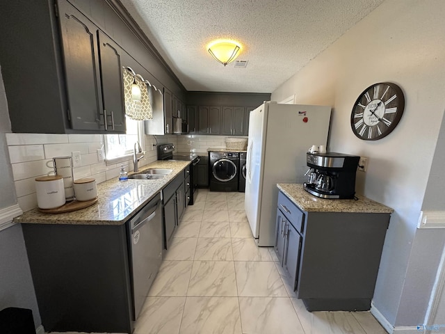 kitchen featuring visible vents, separate washer and dryer, marble finish floor, stainless steel appliances, and a sink