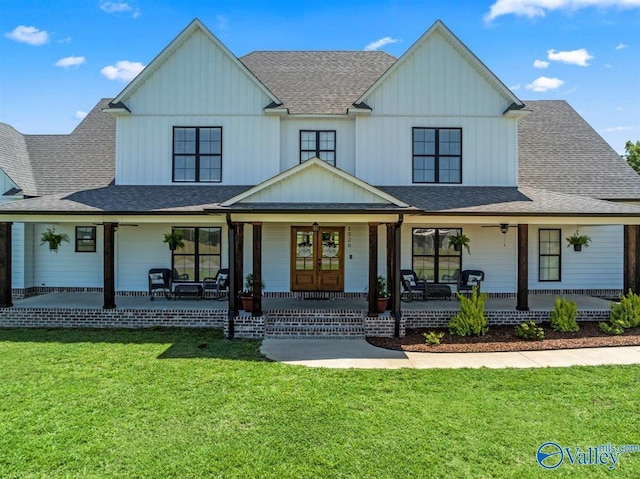 view of front of house featuring ceiling fan, a front lawn, covered porch, roof with shingles, and board and batten siding