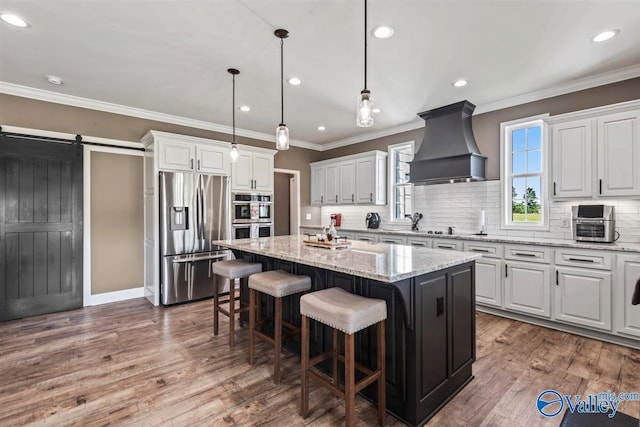 kitchen featuring a kitchen island, tasteful backsplash, white cabinets, custom exhaust hood, and stainless steel appliances