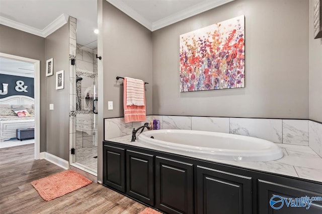 bathroom with wood finished floors, a bath, and a stall shower
