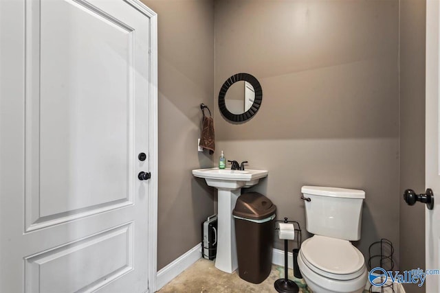 half bathroom featuring toilet and baseboards