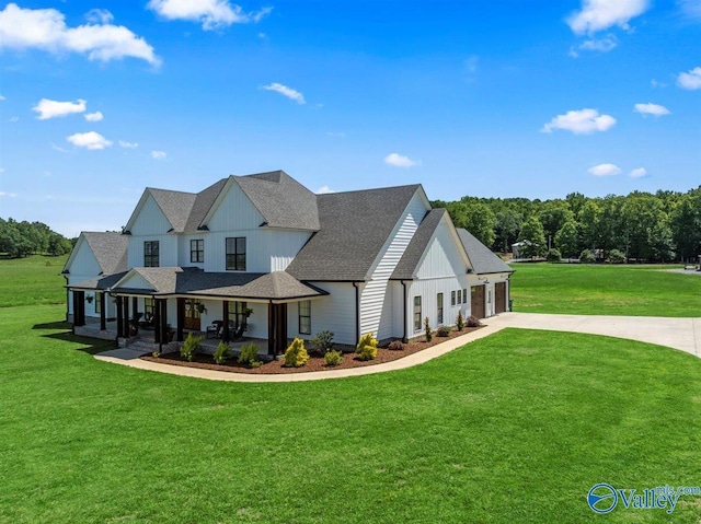 modern farmhouse featuring covered porch, board and batten siding, a front lawn, concrete driveway, and an attached garage