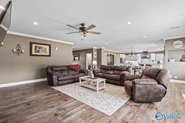 living area featuring recessed lighting, baseboards, ceiling fan with notable chandelier, and wood finished floors