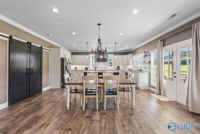 dining space featuring crown molding, recessed lighting, visible vents, and a barn door