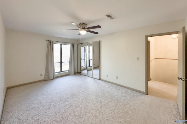 carpeted spare room featuring ceiling fan