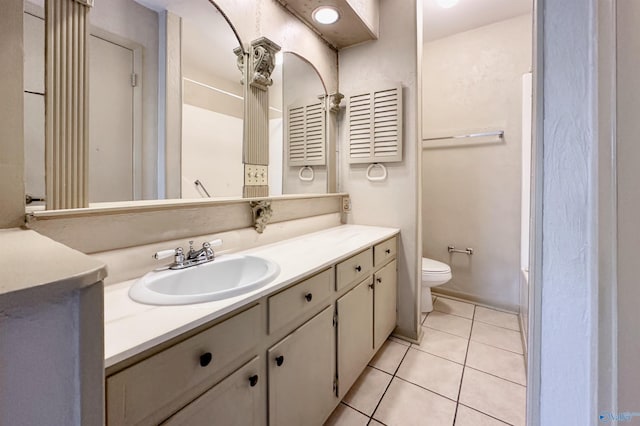 bathroom with vanity, tile patterned flooring, and toilet