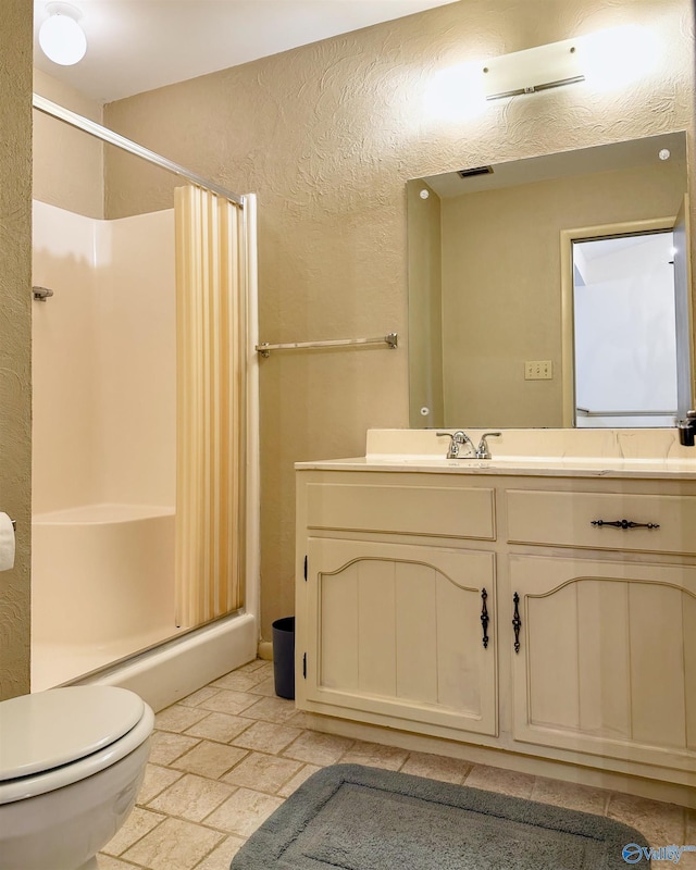 bathroom featuring walk in shower, vanity, and toilet