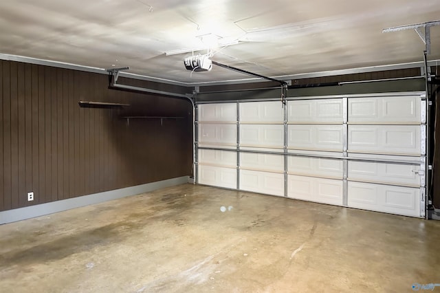 garage featuring a garage door opener and wooden walls