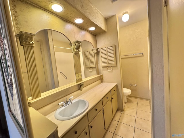 bathroom featuring vanity, toilet, and tile patterned flooring