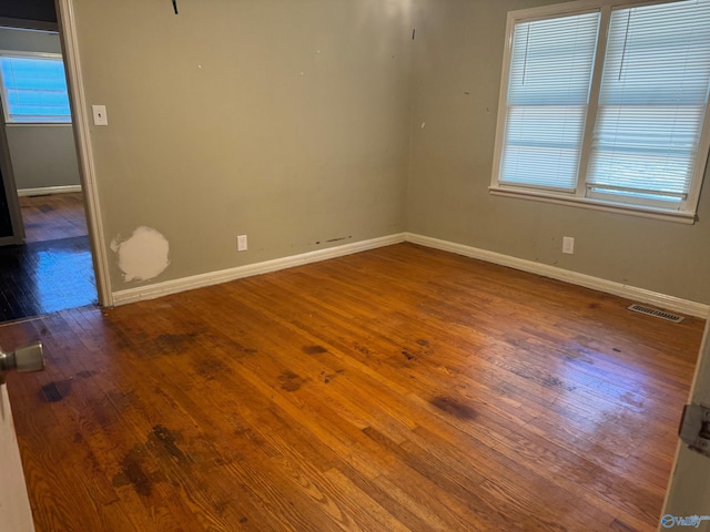 spare room featuring a healthy amount of sunlight and hardwood / wood-style floors