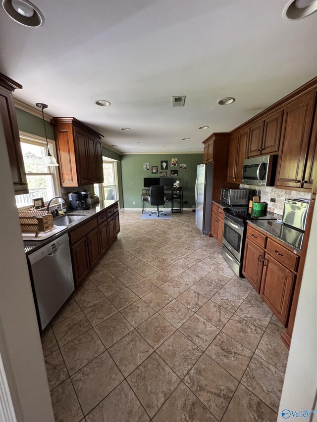 kitchen with a sink, dark countertops, visible vents, decorative backsplash, and appliances with stainless steel finishes