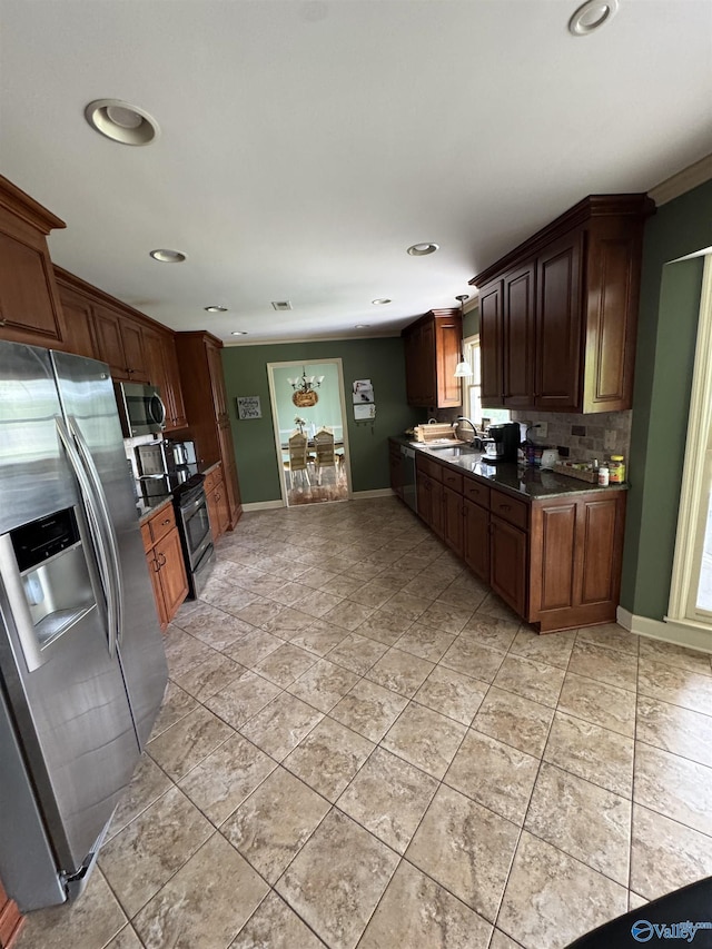 kitchen featuring a sink, dark countertops, recessed lighting, decorative backsplash, and appliances with stainless steel finishes