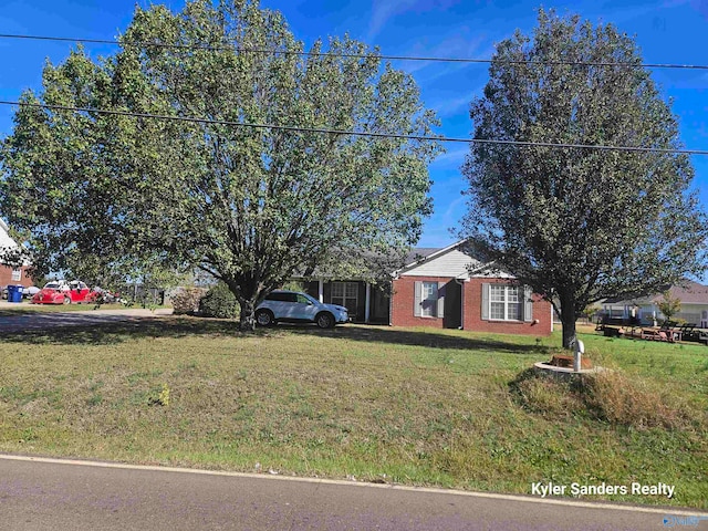 view of front of home with brick siding and a front lawn