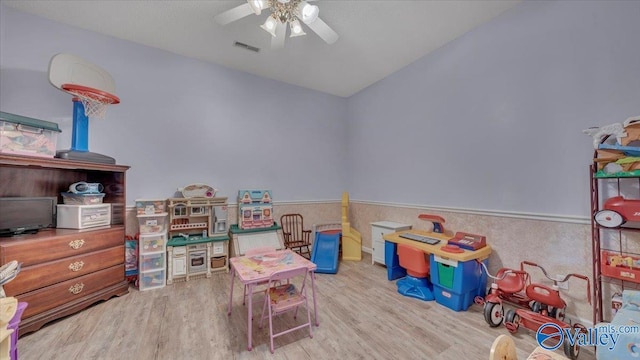 game room featuring lofted ceiling, wood finished floors, visible vents, and ceiling fan