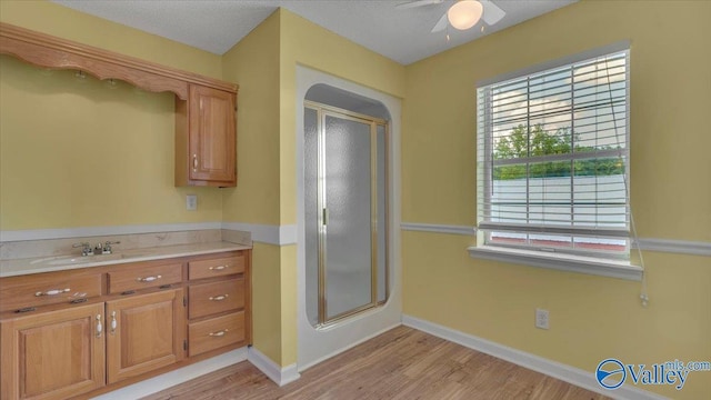 full bath featuring vanity, wood finished floors, and a shower stall
