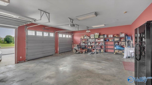 garage featuring a garage door opener and black fridge