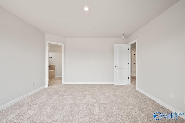 interior space featuring ensuite bath and light colored carpet