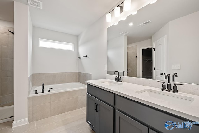 bathroom with tile patterned floors, shower with separate bathtub, and vanity