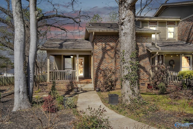 property entrance with covered porch and brick siding