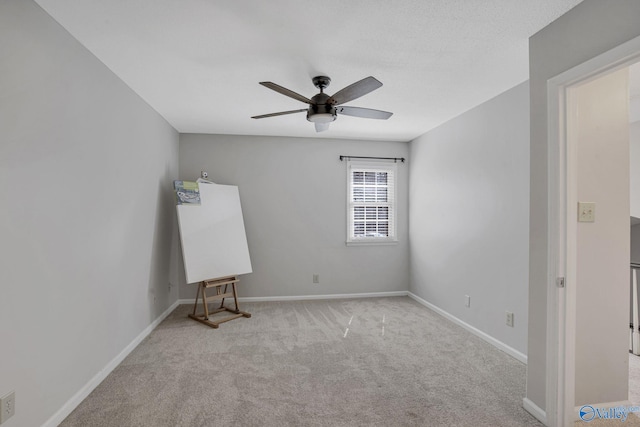 carpeted empty room featuring ceiling fan and baseboards