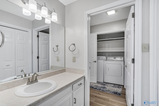 bathroom with washer and dryer, vanity, and wood finished floors