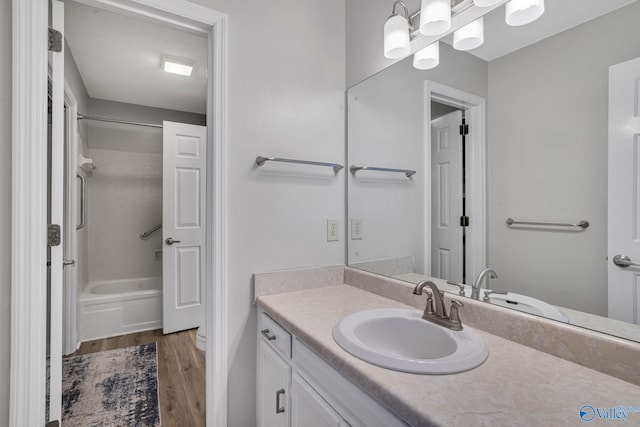 full bath featuring washtub / shower combination, vanity, and wood finished floors